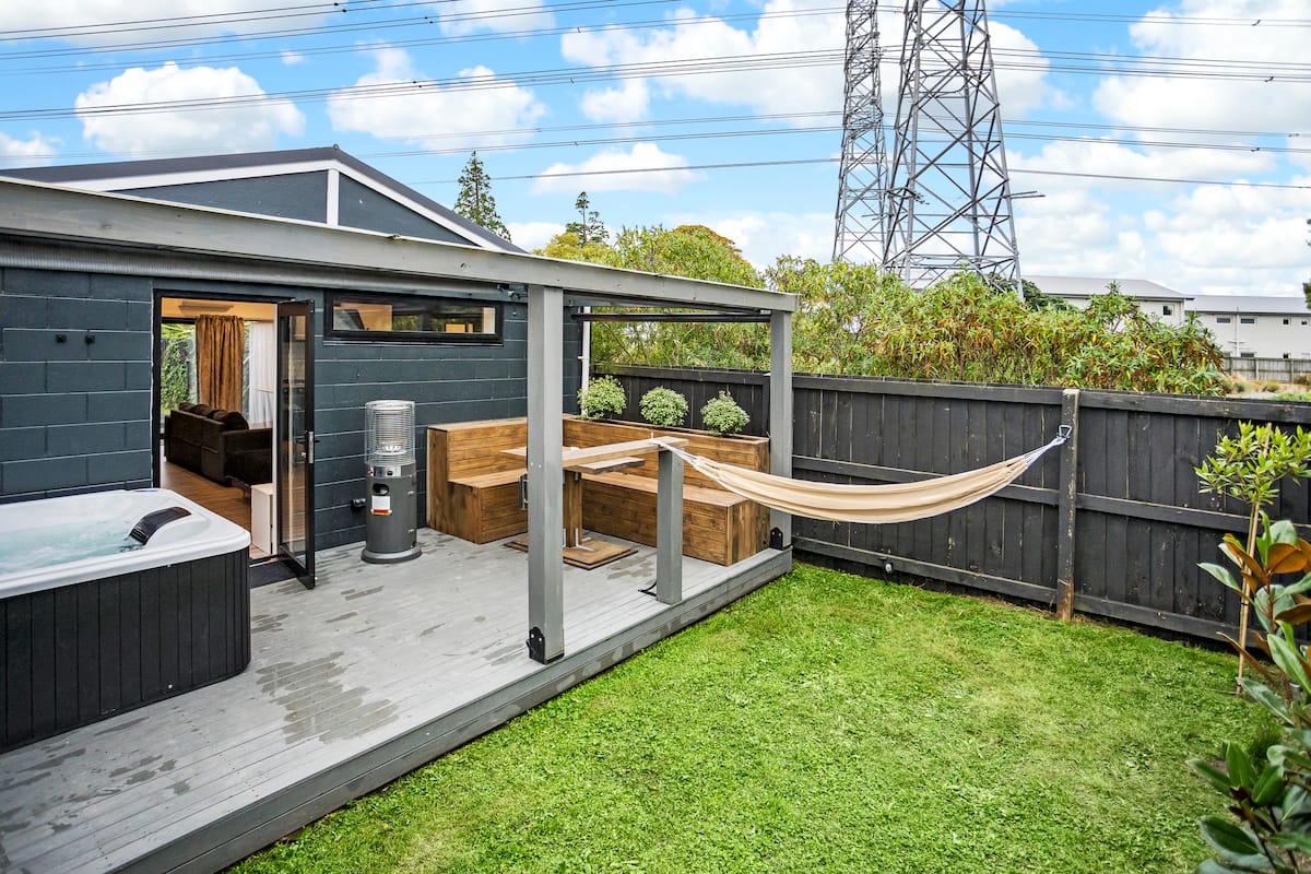 Sunny private backyard with hot tub, hammock and covered patio at the Studio Unit with Spa Bath